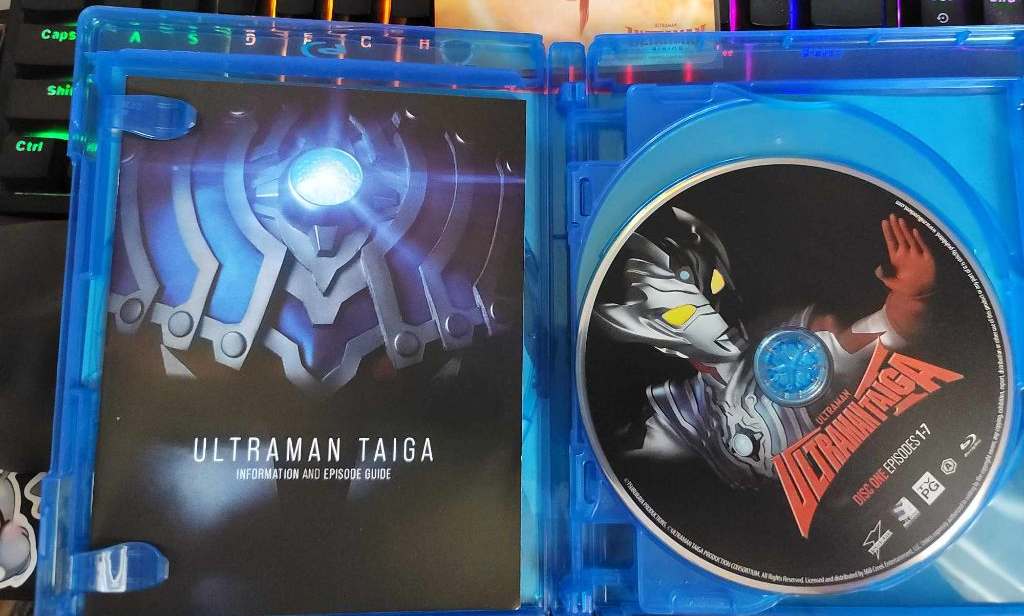 An image of a blu-ray disc, and printed visual guide, included in the ULTRAMAN TAIGA complete blu-ray.