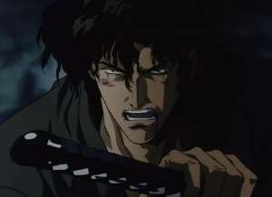 A screengrab from the film NINJA SCROLL. A man, facing the camera, has blood on his face and is drawing his sword.