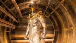 A heroic figure stands in a glowing white suit