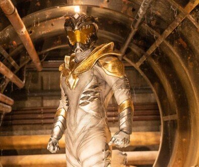 A heroic figure stands in a glowing white suit