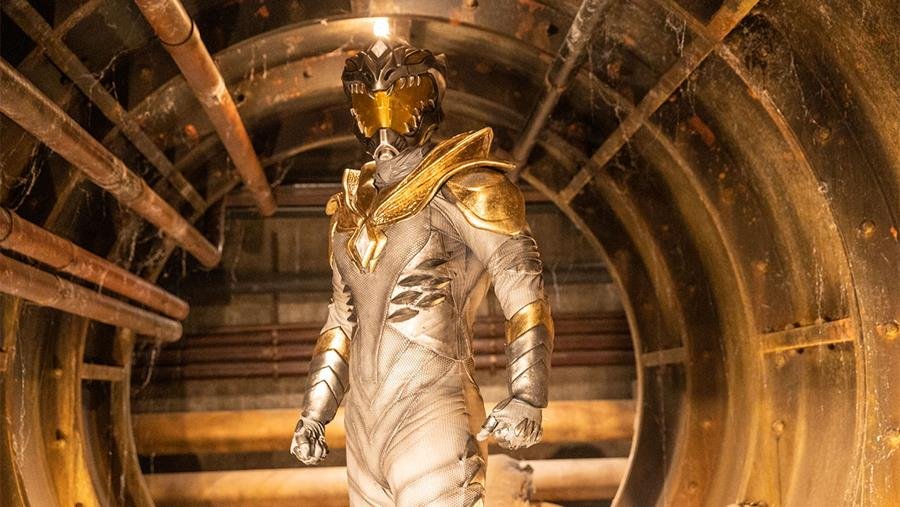 A heroic figure stands in a glowing white suit