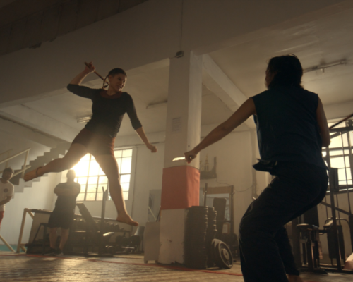 Two people fighting in a gym.