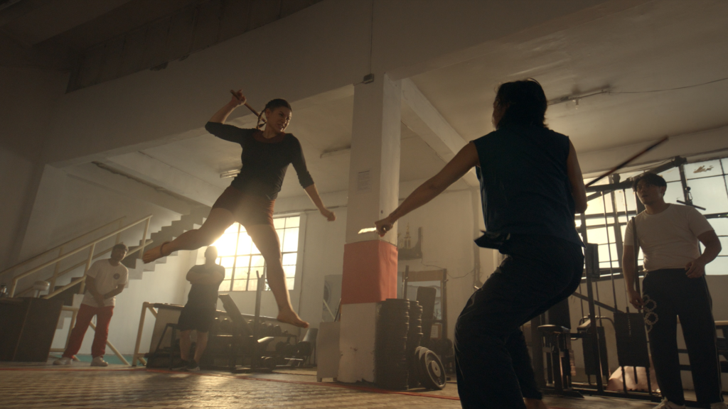 Two people fighting in a gym.